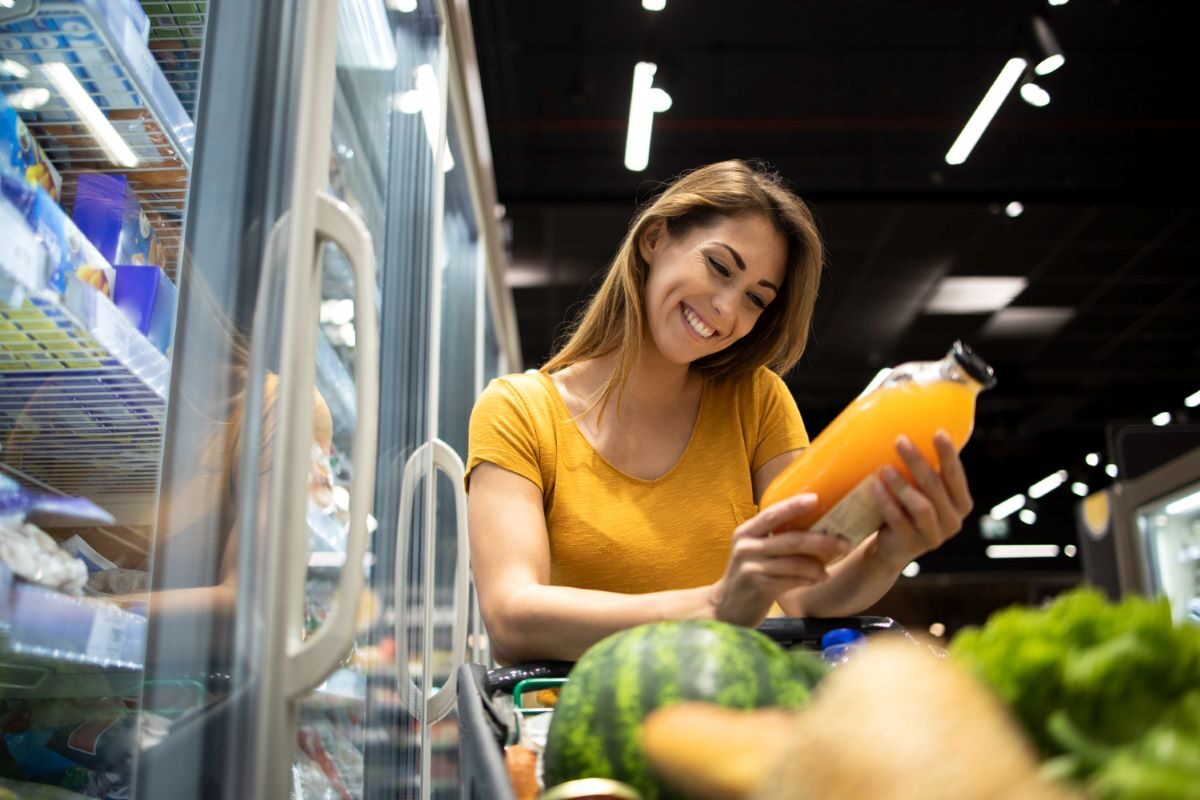 mujer viendo etiqueta nutricional de jugo