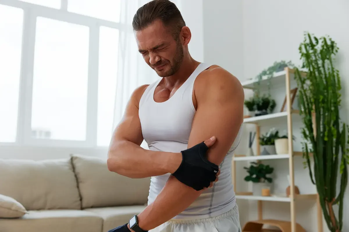 persona con guantes de gimnasio y dolor de codo